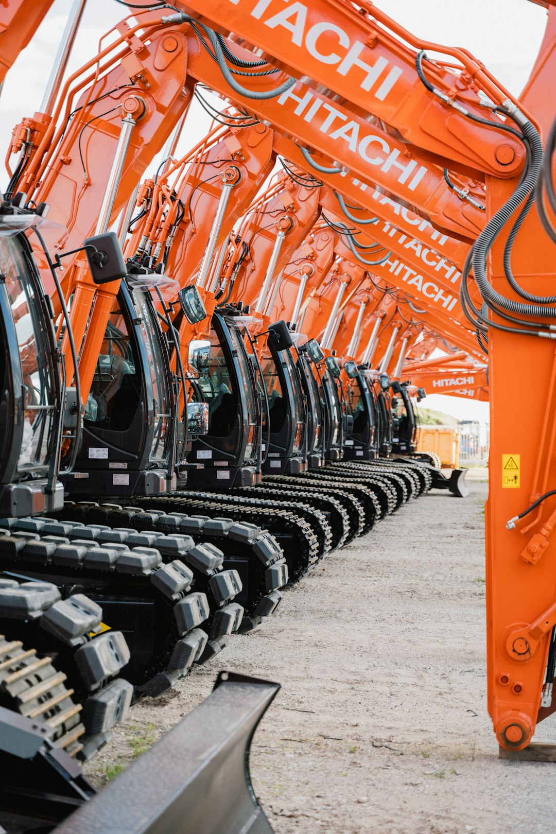 who-we-are Eine Reihe von Hitachi Baggern, die für den Einsatz auf einer Baustelle bereitstehen. Diese modernen und leistungsstarken Maschinen sind ideal für eine Vielzahl von Bauprojekten und zeigen die Effizienz und Zuverlässigkeit von Hitachi Baumaschinen