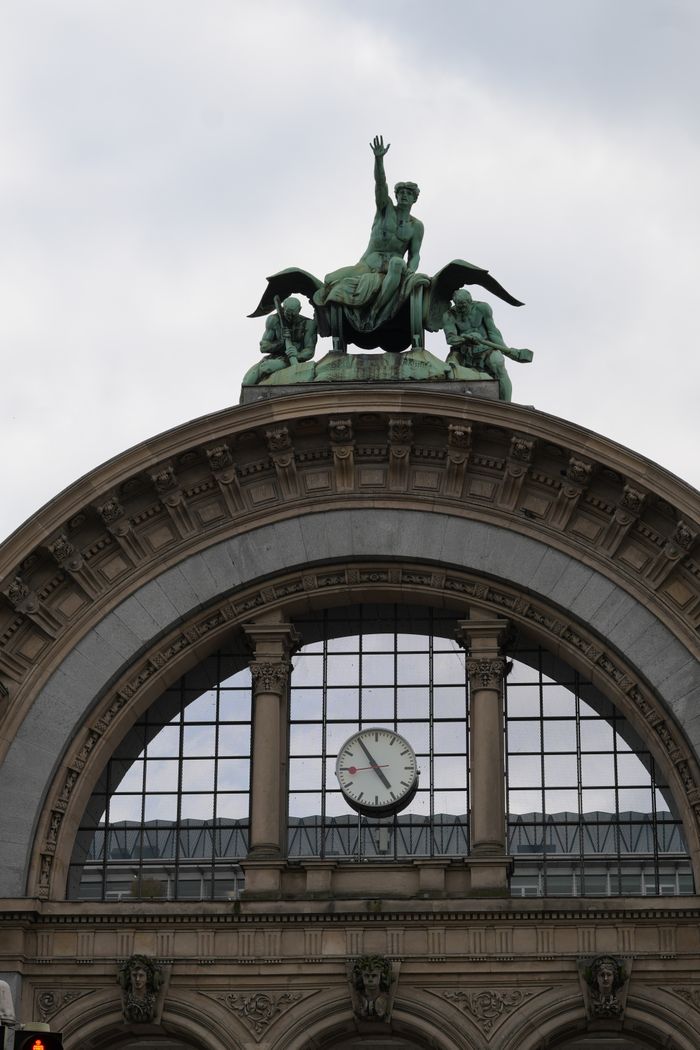 Detailed view of Luzern Station arch with iconic sculpture and clock.